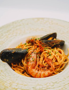 Bir tabak spagetti, deniz ürünü ve domates soslu.