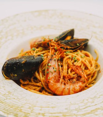 Bir tabak spagetti, deniz ürünü ve domates soslu.