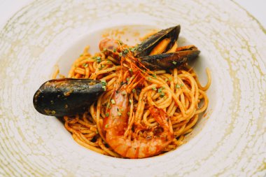 Bir tabak spagetti, deniz ürünü ve domates soslu.