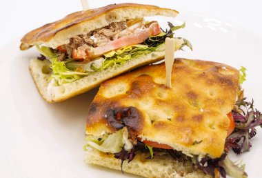 Ciabatta ekmekli sandviç, yanında domuz eti ve sebze.