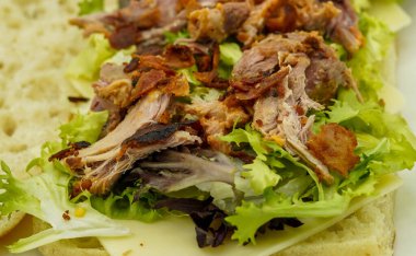 Ciabatta ekmekli sandviç, yanında domuz eti ve sebze.