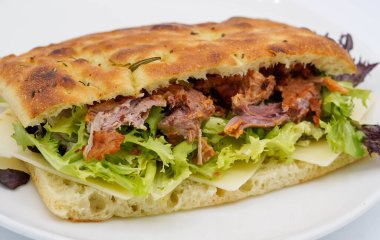 Ciabatta ekmekli sandviç, yanında domuz eti ve sebze.
