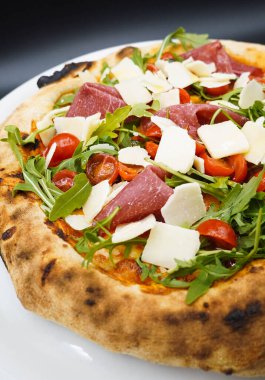 Haşlanmış jambon, parmesan peyniri ve roka ile yapılmış tipik bir Napoli pizzası.