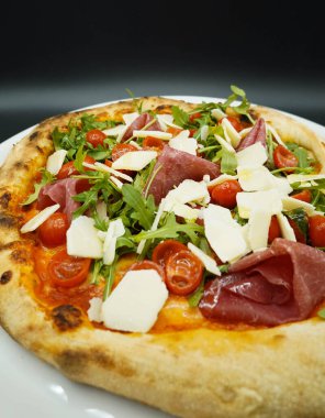 Haşlanmış jambon, parmesan peyniri ve roka ile yapılmış tipik bir Napoli pizzası.