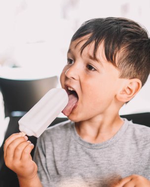 Kafkasyalı çocuk hindistancevizi lolipopunun keyfini çıkarıyor.