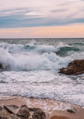 Landscape of a beach shore with waves and foam