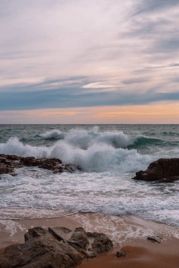 Landscape of a beach shore with waves and foam