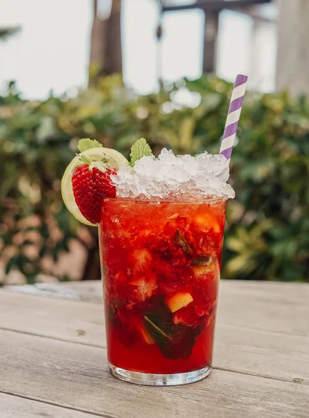 A strawberry Mojito made with rum, mint, sugar and lime