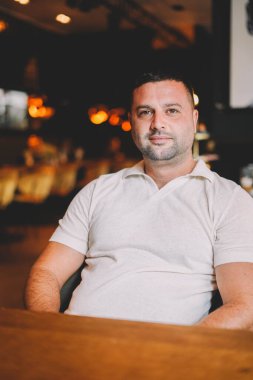 Orta yaşlı bir adam bir barda kahvaltı yapıyor.