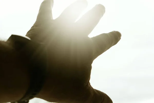 Güneşi gösteren bir insan eli.