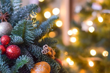 A small Christmas tree with toys on a blurry background with lights