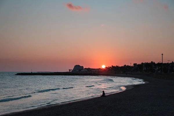 Gün batımında deniz kenarında meditasyon yapan kadın silueti, yalnızlık, romantik ruh hali, Sitges, İspanya