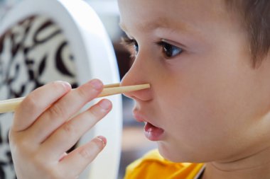 Küçük komik çocuk yemek çubukları kültür, Japon geleneksel rulo suşi yemek yiyor