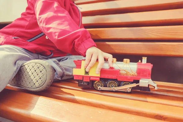 Çocuk çocuk oyuncak tren ile açık havada sıcak yaz gününde oynuyor. Küçük çocuklar için oyuncaklar