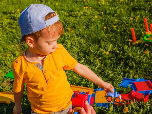 Menino Brinca Com Carro Brinquedo Gramado Grama Verde Parque — Fotografia de Stock