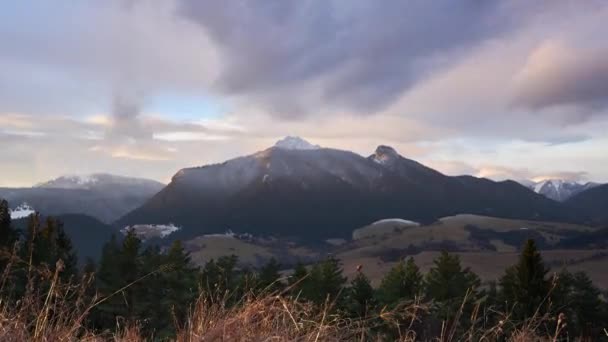 Morgen winterlandschap, besneeuwde bergtoppen. Wolken in beweging bij zonsopgang — Stockvideo