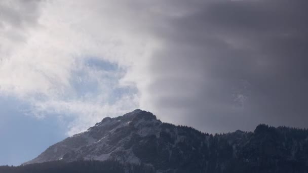 Dense clouds over the rocky peak. Windy winter weather. Clouds and fog — Vídeo de Stock