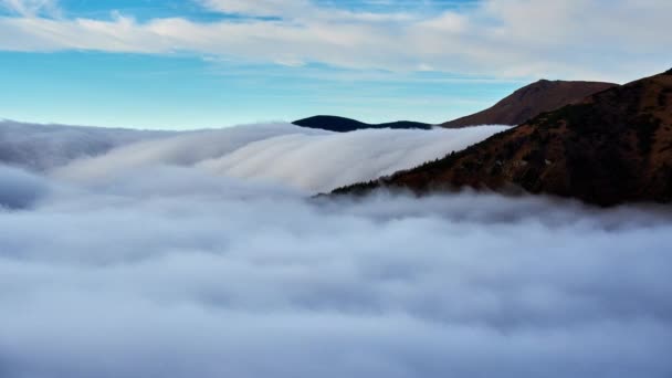 Cloud inversion, clouds spill over the mountain, waterfall from the clouds — Video