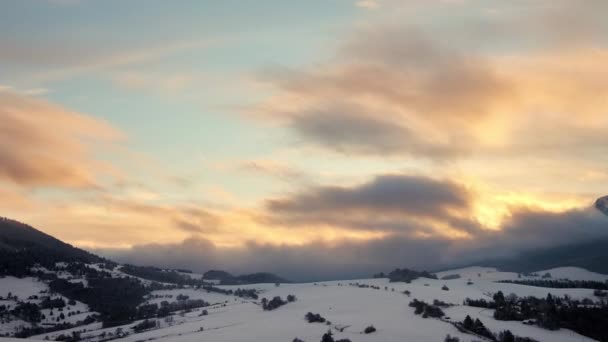 Hegyi téli táj. A lucfenyőket hó borítja. Alacsony felhők mozognak az égen naplementekor, alkonyatkor. — Stock videók