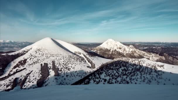 Paisaje montañoso invernal en un día soleado con nubes, cielo azul. Montaña nevada, paisaje panorámico — Vídeo de stock
