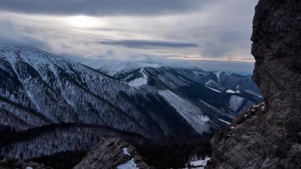 Nuvole turbolente ondeggiano sulle cime delle colline in inverno Stand di abete rosso, da dietro le rocce. — Video Stock