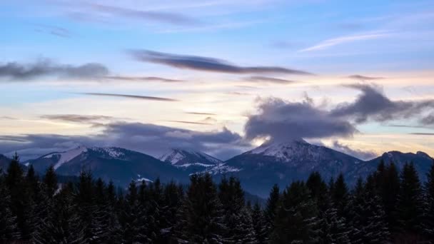 Paisaje montañoso invernal al atardecer, nubes sobre picos alpinos de montaña — Vídeo de stock