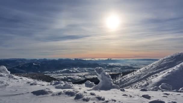 中午时分的山地冬季景观。阳光透过稀疏的云彩照耀着.雪层4K — 图库视频影像