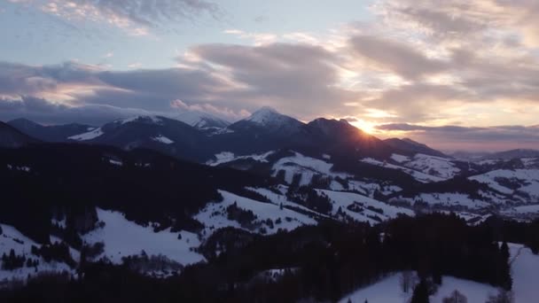 Flygfoto solnedgång över vintern berg träd landskap, färgade moln i skymningen. 4K stock video. — Stockvideo