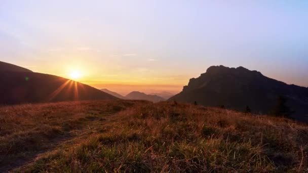 Zachodzące słońce w górach w parku narodowym, trawa oświetlona promieniami słońca, — Wideo stockowe