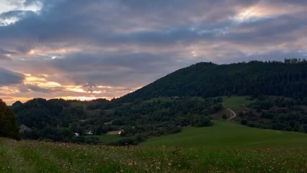 Zonsondergang over de heuvels op een groene weide op het platteland in de zomer, FHD timelapse — Stockvideo