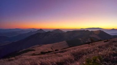 Mountain landscape at sunrise, mountain meadow, grass ripples in the wind , clear sky