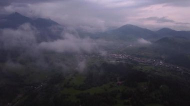 Kırsaldaki sisli dağların ve tepelerin üzerinden uçuyorlar. Kırsal kesimde güzel kasvetli bir gün. Yüksek kalite 4k görüntü