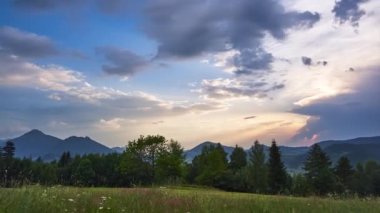Yazın güzel dağ doğası. Bulutlar ve manzara batan güneşin zengin renkleriyle boyanır, Stromya çimenli çayırları ön planda, tepeler ve dağlarla ormanlar, panoramik çekim