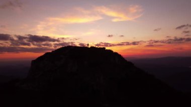 Sinematik hava aracı hala görünüyor. Dağlarda gün doğumu ya da günbatımı, güneşin altında dağların üzerinden uçmak. Yüksek kalite 4k görüntü