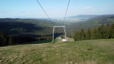 Baharda yamaçlarda teleferiklerin arasında uçmak. Güneşli bir günde orman manzarası. Yüksek kalite 4k görüntü