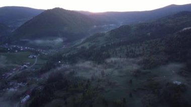 Aerial view over rural mountain landscape. Dense inversion clouds are holding in the valley. High quality 4k footage