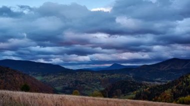 Akşam karanlığında kırsal dağ manzarası. Gün batımında yoğun bulutlar. Güzel sonbahar atmosferi. Yüksek kaliteli FullHD görüntüler