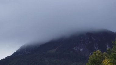 Sisli bir dağ zirvesinde hızlı bulutların hızlandırılmış hareketi. Yakınlaştır. Yüksek kalite 4k görüntü