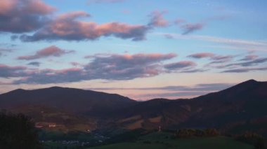 Alacakaranlıktaki dağ manzarası. Mavi gökyüzünde yavaşça hareket eden bulutlar. Sabahtan akşama kadar. Yavaşça büyüt, yüksek kalite 4K görüntü