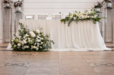 Düğün resepsiyonundaki ana masada güzel taze çiçekler var.