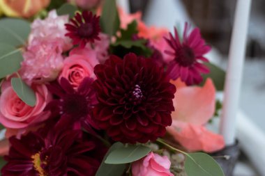 Temiz vazoları ve renkli çiçekleri olan beyaz masa örtüleri. Altın renkli tabaklar, peavh peçeteleri, masa numaraları ve ayna süslemeleri. Düğün günü..