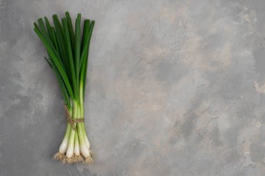 gri taş zemin üzerine yeşil soğan.