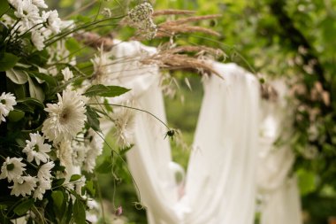 Düğün töreninin dışında. Çok güzel ve şık bir düğün kemeri, çeşitli taze çiçeklerle süslenmiş, bahçede duruyor. Düğün günü..