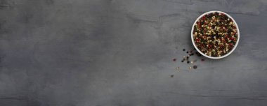 Üç çeşit biber, beyaz, siyah ve kırmızı gri taşlı arka planda beyaz bir kasede. Baharatlar