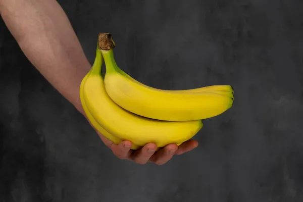 Mão Homem Segura Monte Bananas Fundo Escuro — Fotografia de Stock