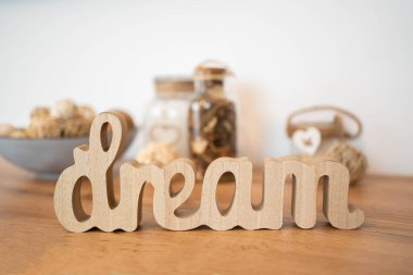 Tahta masada ve beyaz duvarda rüya yazıları var. Rüya konsepti. Kutu arkaplanı.