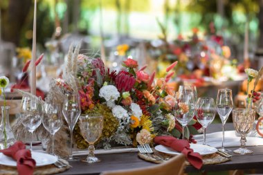 Çok güzel dekore edilmiş bir düğün masası randevusu. Baharın bahçesinde tabaklar ve peçetelerle süslenmiş güzel bir dekor. Düğün günü masada güzel çiçekler. Zarif yemek masası. Boho düğünü..