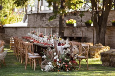 Çok güzel bir şekilde dekore edilmiş düğün tablo randevular plakaları ve peçeteler bahar bahçe içinde güzel bir dekor ile. Düğün günü masaya güzel çiçek. Zarif yemek masası.
