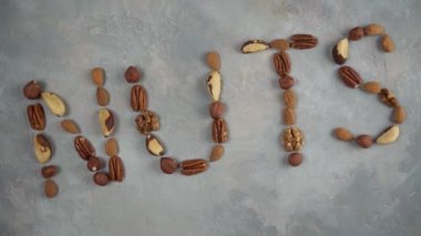Açık gri arka planda fındık karışımından çıkan fındık kelimesi..