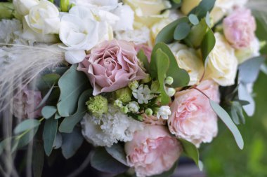 Gül, frezya, östoma ve koyu arkaplanda okaliptüsten yapılmış modern gelin buketi. Düğün günü..